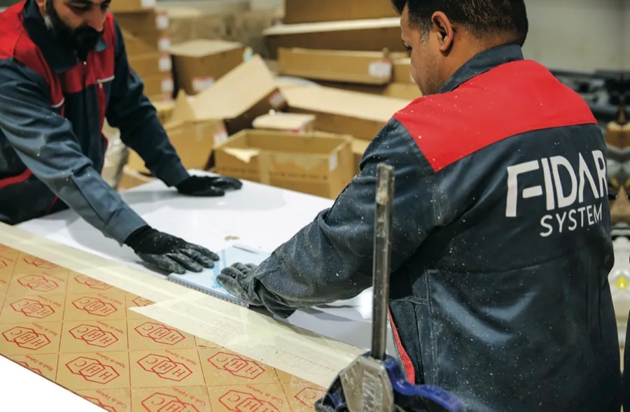 Fidar System team members handling acrylic sheet fabrication in the North York warehouse
