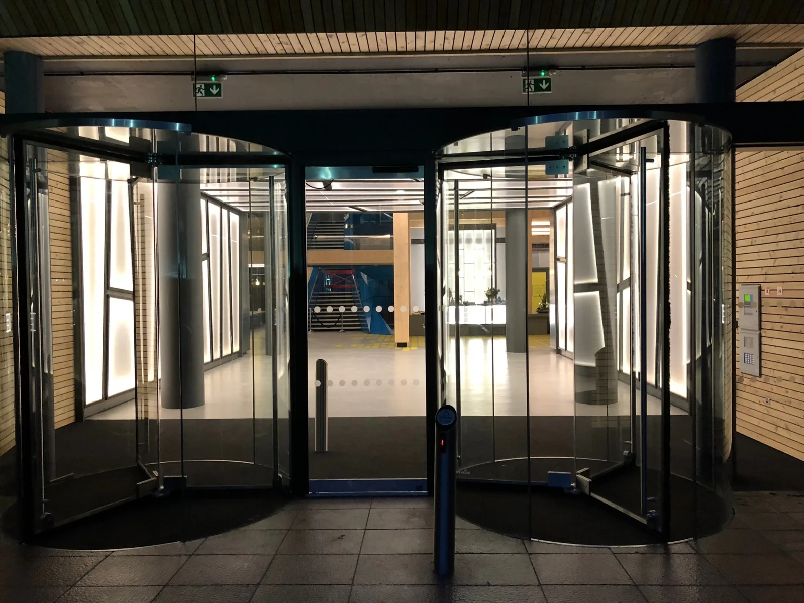 Backlit Bencore panels lining the walls of a building entrance at night