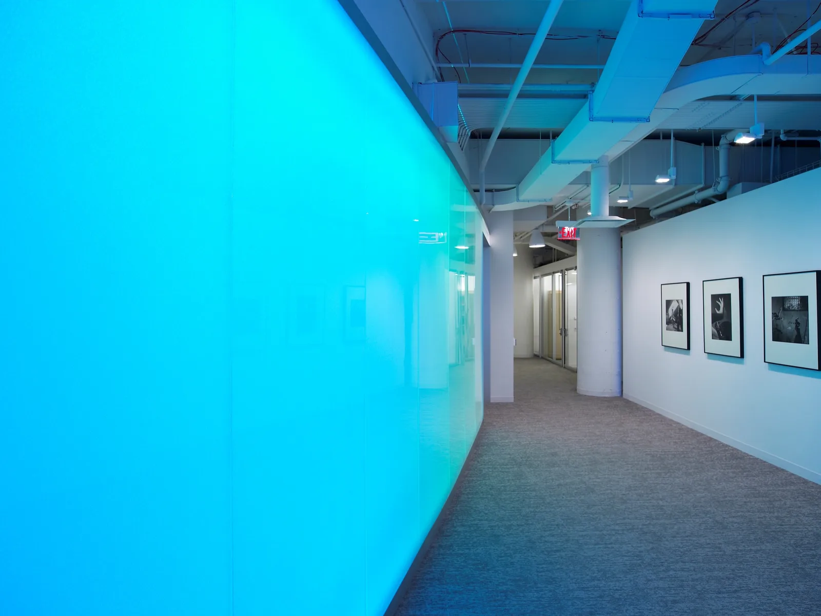 Backlit blue panel wall lighting an office corridor, from Bencore's 2024 presentation