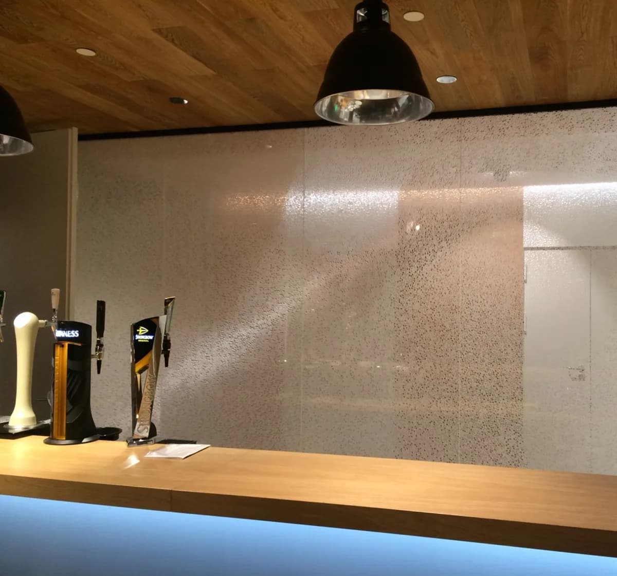 Bubble patterned panels used as a lit wall behind a bar counter