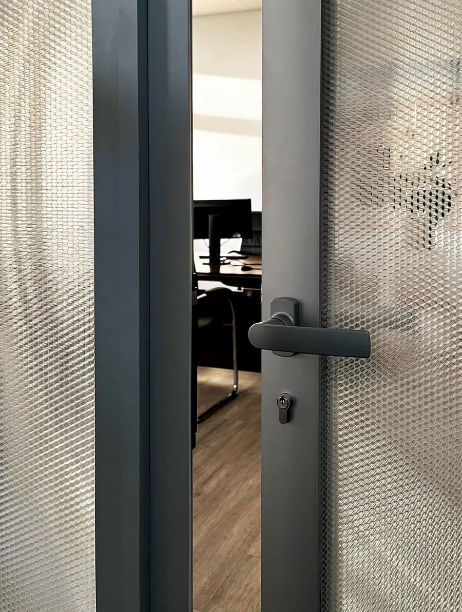 Lever handle on a Crystal glazed door, the honeycomb core visible between the glass