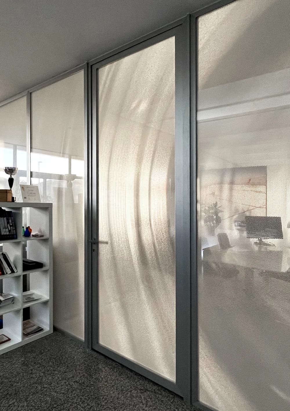 Crystal double glazed partition wall with a Lightben core, light sweeping across the honeycomb between the glass