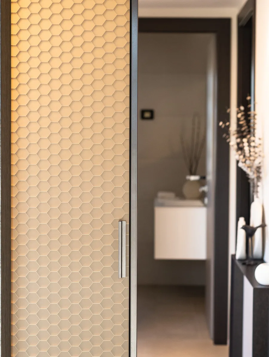 Fos door with a gold hexagonal honeycomb panel beside a hallway