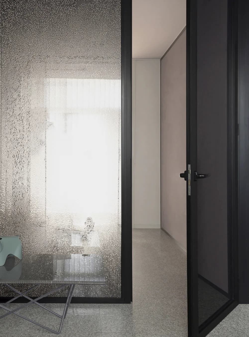 Koros swing door open onto a corridor, light passing through the honeycomb panel