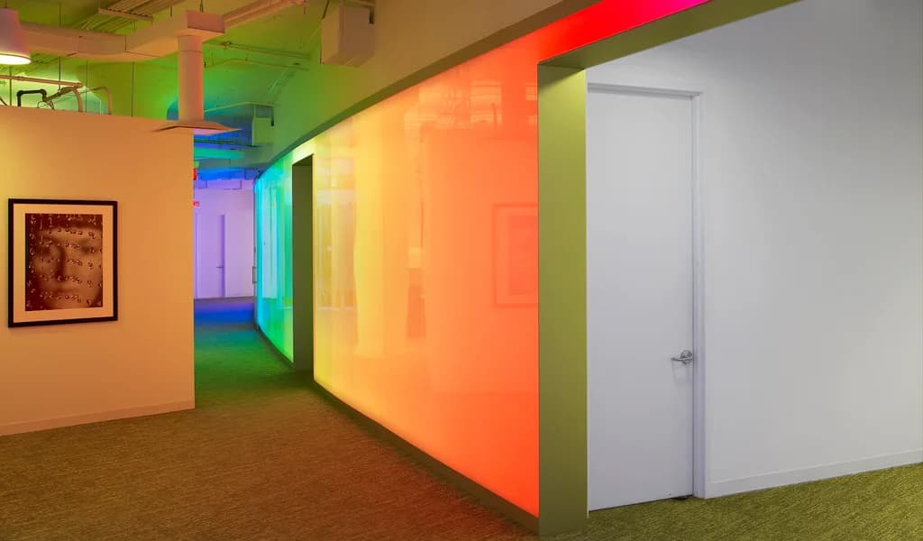 Colour changing backlit Lightben wall curving along a corridor at Lifetime Networks in New York, by HOK