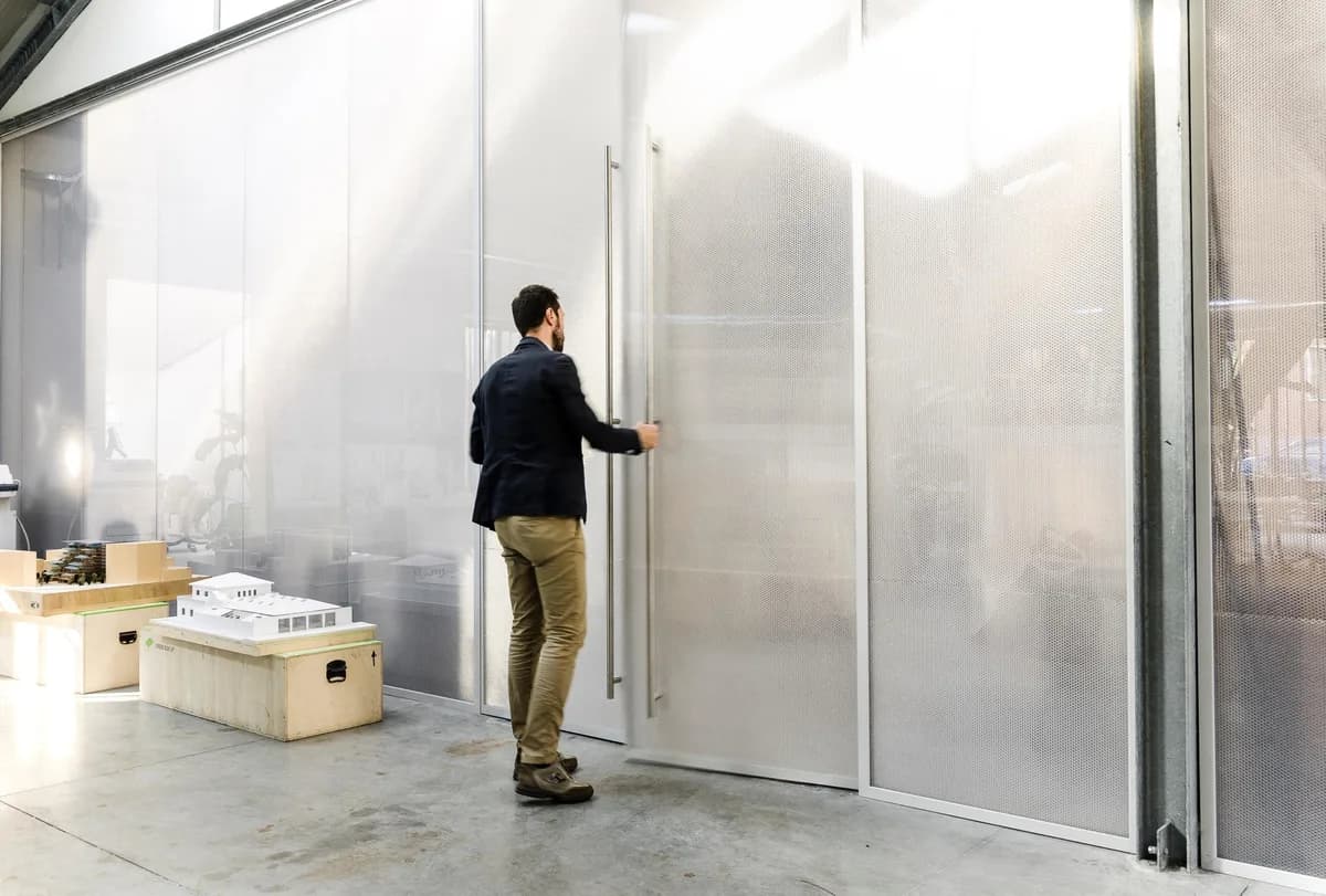 Translucent Bencore doors and walls in the Mario Cucinella Architects studio with a model city in front