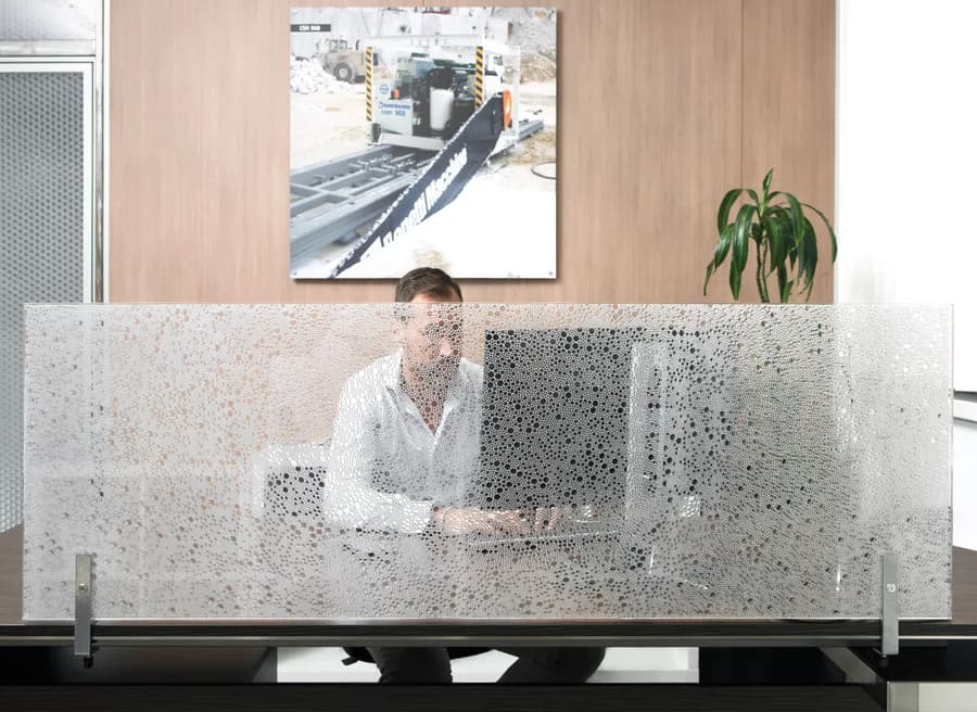 Bubble patterned desk divider in front of a person working at a laptop
