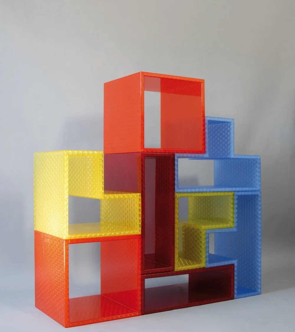 Tetris modular bookcase in red, yellow, blue and dark red Starlight elements stacked into an interlocking tower