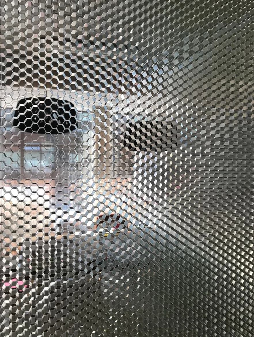 Close view of a bubble patterned panel in a Wallite wall with chairs behind it